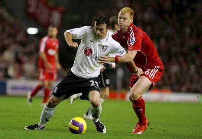 لاعب ليفربول جون أرنه ريسه (اليمين) يحاول قطع الكرة من لاعب فولهام سيمون دافيز