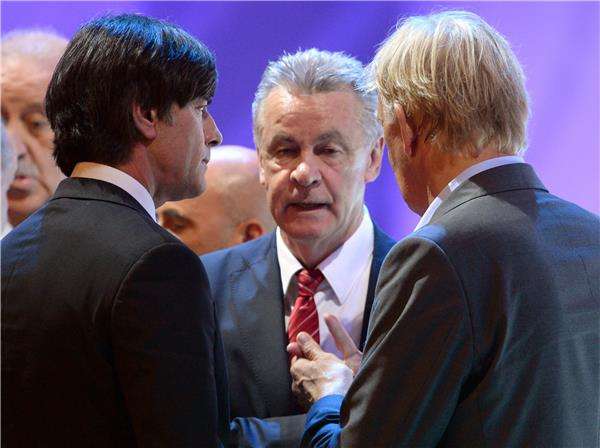 هيتزفيلد يتوسط لوف (يسار) وفولكر فينكه مدرب الكاميرون (يمين)