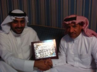 الكابتن صالح خليفة على يمين الصورة يستلم درع كووورة من الزميل خلف الدوسري