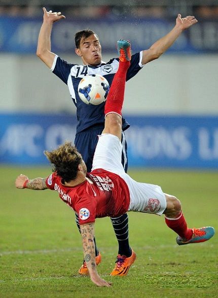 ديامانتي في صراع كروي مع لاعبي فريق ملبورن الاسترالي