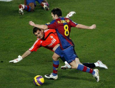 الحارس كاسياس يحاول التصدي لكرة لاعب برشلونة اينيستا