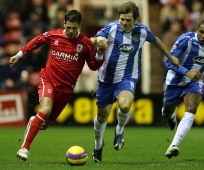 جيمي ألياديـر (يسار) يحاول المرور من أمام مدافع ويغـان كيفن كيلبـان