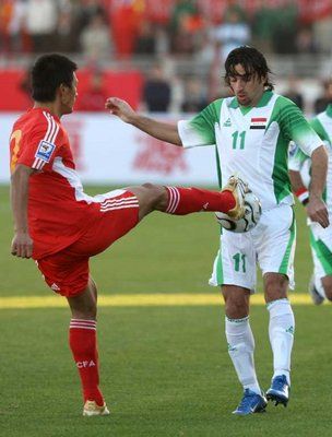 اللاعب العراقي هوار ملا محمد واللاعب الصيني شواي زهانج في صراع على الكرة