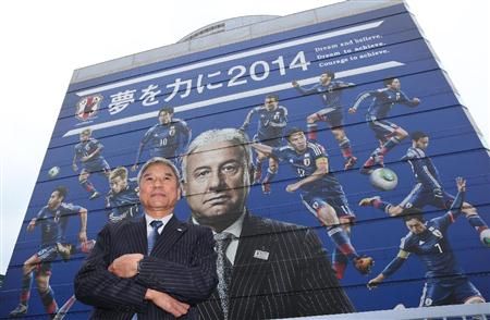 رئيس الاتحاد الياباني كونيا دايني أمام الملصق الضخم