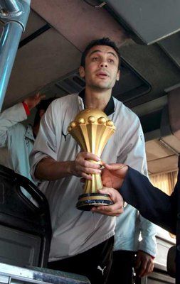 كابتن أبطال أفريقيا أحمد حسن حاملا الكأس بعد وصول الفريق الى مطار القاهرة الدولي