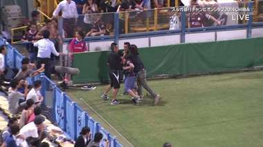 صورة تلفزيونية من (قناة فوجي اليابانية) لاقتحام مشجعي لانوس لأرضية الملعب