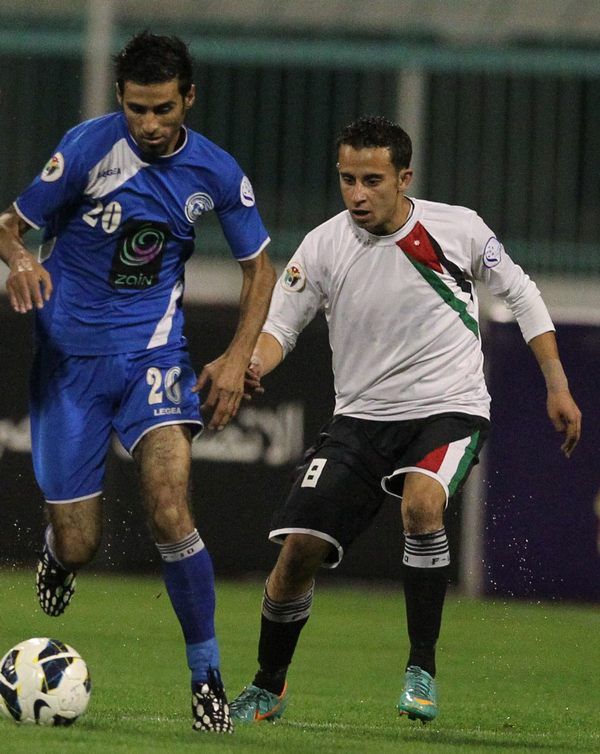 أحمد غازي "الرمثا" يسير بالكرة ويطارده شديفات "المنشية" 