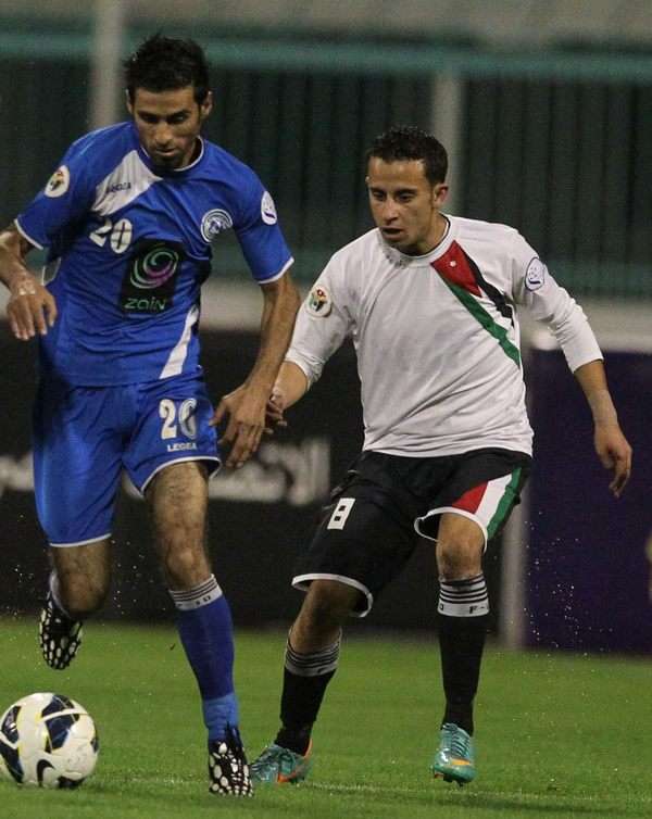 أحمد غازي "الرمثا" يسير بالكرة ويطارده شديفات "المنشية" 