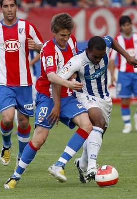 لاعب ريكرياتيفو بونغول (يمين) وكاماتشو من أتلتيكو (يسار)