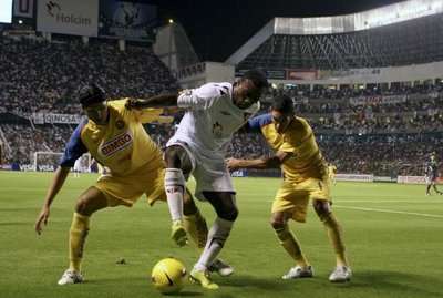 جيرون (وسط الصورة) محاصرا بين إثنين من لاعبي فريق كلوب أمريكا المكسيكي