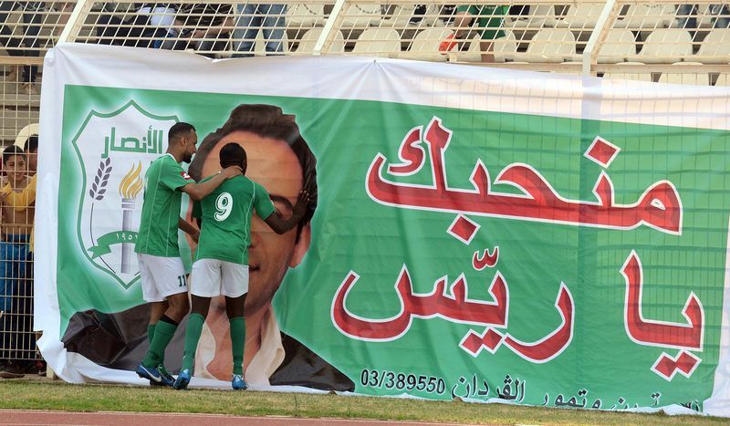 نجم الانصار النيجيري برنس يقبل صورة بدر بعد تسجيله لفريقه في مباراة الديربي 