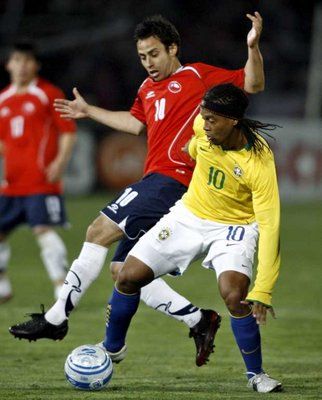 رونالدينيو مع الكرة وسط مضايقة من الشيلي فالديفيا