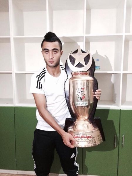 زكريا اللافي يحمل كأس بطولة الدوري الليبي الذي تُوج به مع فريقه السابق أهلي طرابلس موسم 2014