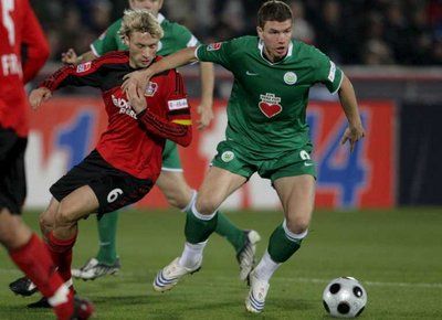 لاعب ليفركوزن سيمون رولفز يحاول قطع الكرة من ادين دزيكو لاعب فولفسبورغ