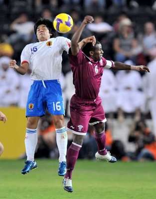 الياباني أكوبو في صراع على الكرة مع النجم القطري مبارك مشعل