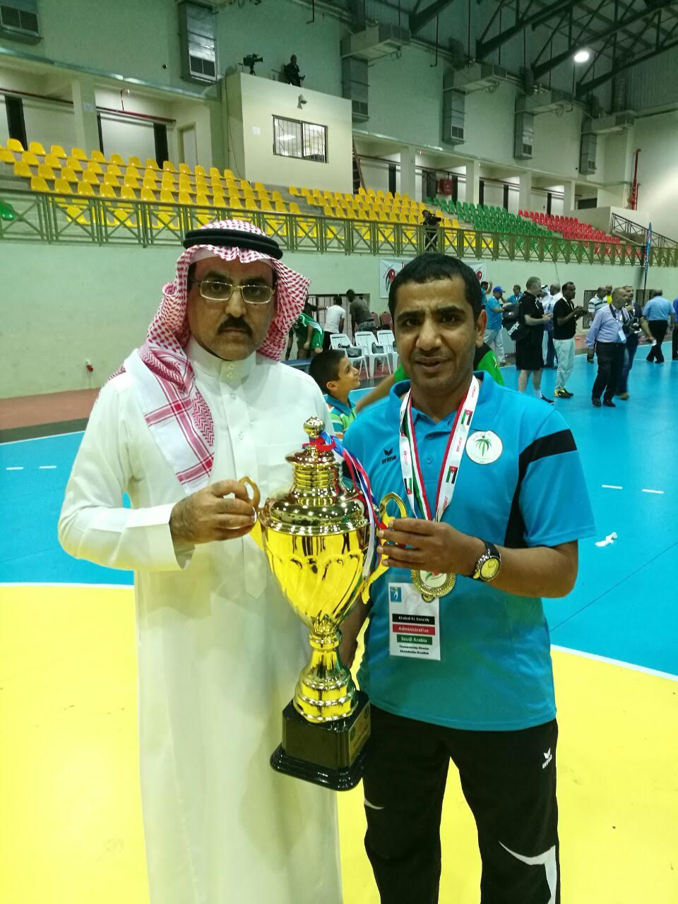 رئيس الاتحاد السعودي لكرة اليد تركي الخليوي يحمل كأس المركز الثاني 