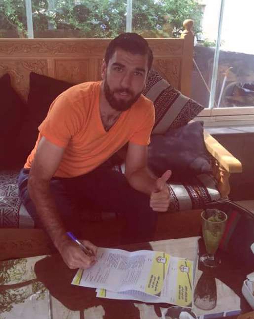 تامر حاج محمد أثناء توقيعه العقد