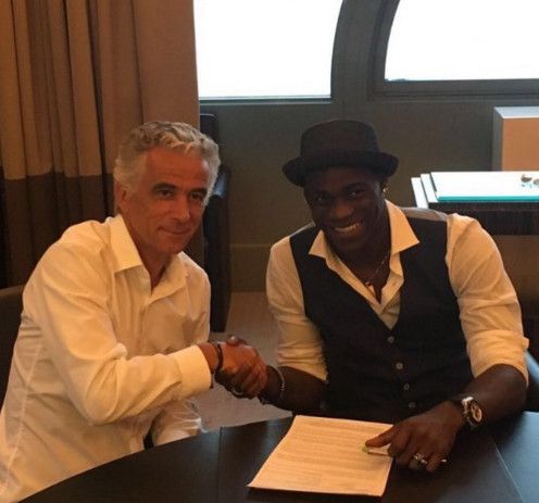 ماريو بالوتيلي أثناء توقيعه العقد