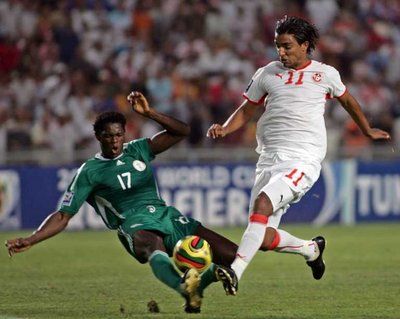 المهاجم التونسي سامي العلاقي يحاول تجاوز المدافع النيجيري