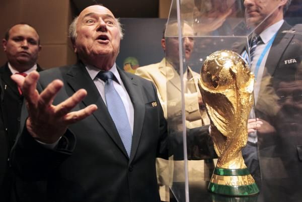 رئيس الفيفا السابق بلاتر في صورة أرشيفية مع كأس العالم