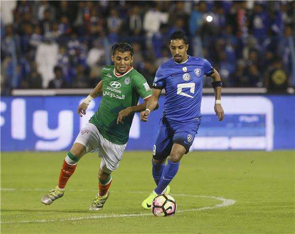لاعب الهلال الدوسري (يمين) في صراع مع مهاجم الاتفاق ياسماني دوك 