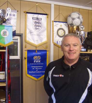 السيد والشـو يقف أمام كؤوس وأوسمة النادي