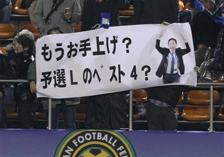 مشجع رفع لافتة تستهزأ بطموح السيد أوكادا وهو بلوغ دور النصف النهائي بكأس العالم 2010