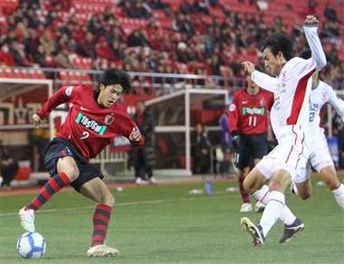 الظهير الأيمن أتسوتو يوتشيدا يحاول مراوغة أحد مدافعي الفريق الصيني