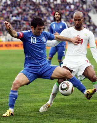 اليوناني كاراجونيس يحاول نيل الكرة قبل السنغالي تافاريز