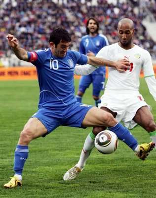 اليوناني كاراجونيس يحاول نيل الكرة قبل السنغالي تافاريز