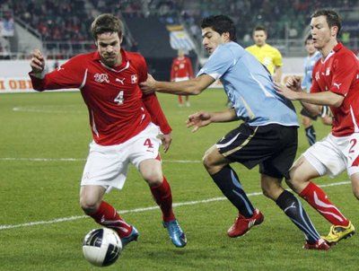 السويسري روسينا يحاول حماية الكرة من مهاجم الارغواي سواريز