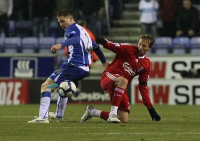 لاعب ليفربول لوكاس يحاول نيل الكرة قبل اللاعب ماكارثي