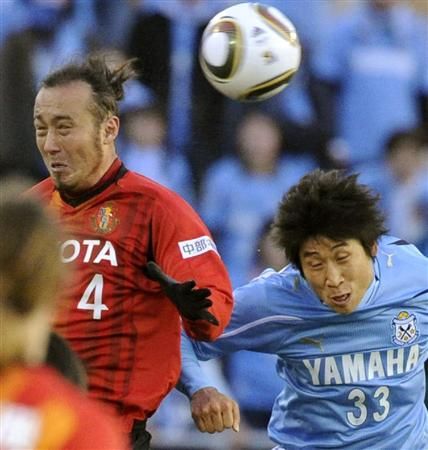 صراع هوائي بين المدافع توليو تاناكا ( يسار ) والمهاجم الكوري الجنوبي الدولي لي كيون هو