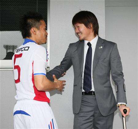 تايشي تسوكاموتو ( يمين ) يهنئ ظهير أيسر فريق طوكيو الدولي ناغاتومو بعد إنتصاره بالمباراة