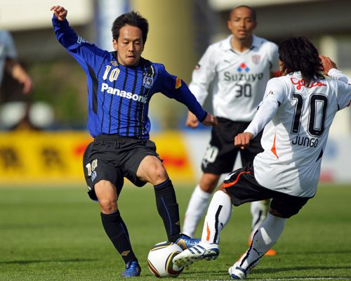 لاعب الوسط فوتاغاوا يحاول تجاوز مدافعي شيميزو في مباراة جامبا وشيميزو