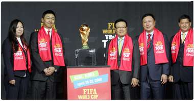 السيد جونغ مو وبجانبه أعضاء الإتحاد الكوري الجنوبي يقفون بجانب كأس العالم