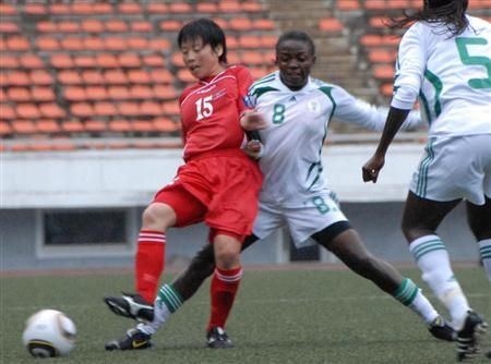 إحدى لاعبات منتخب كوريا الشمالية تحاول إختراق دفاع سيدات نيجيريا بمباراة الامس