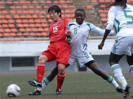 إحدى لاعبات منتخب كوريا الشمالية تحاول إختراق دفاع سيدات نيجيريا بمباراة الامس