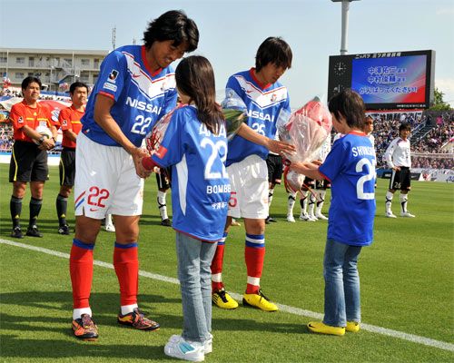 ناكامورا ( يمين ) وناكازاوا يتلقون التهنئة والورود بعد ضمان تواجدهم في جنوب أفريقيا