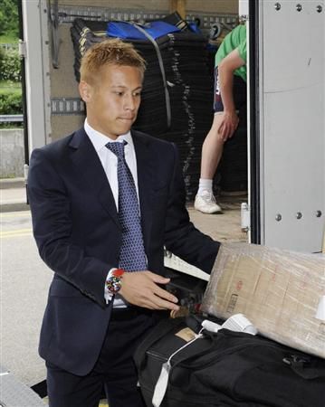 كيسوكي هوندا يحمل حقائبه عند وصوله لسويسرا