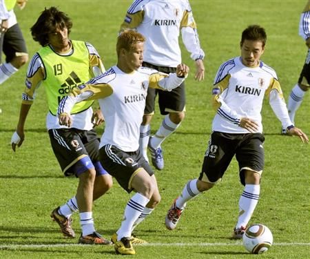 كيسوكي هوندا ( الوسط ) يحاول تجاوز المدافعان ناكازاوا وناغاتومو