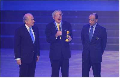 السيد أوغورا ( الوسط ) بعد إستلامه الجائزة من جوزيف بلاتر