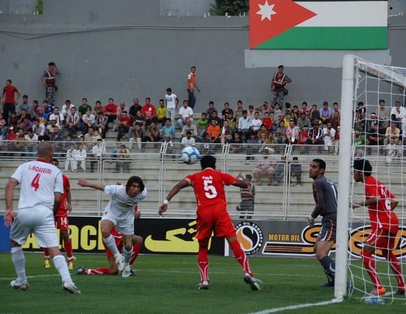 سيد هادي عقيلي وكرة راسية يبعدها دفاع البحرين