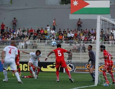 سيد هادي عقيلي وكرة راسية يبعدها دفاع البحرين