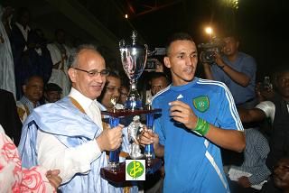 قائد فريق تفرغ زينه يتسلم الكأس من يد الوزير الأول (و.م.أ)