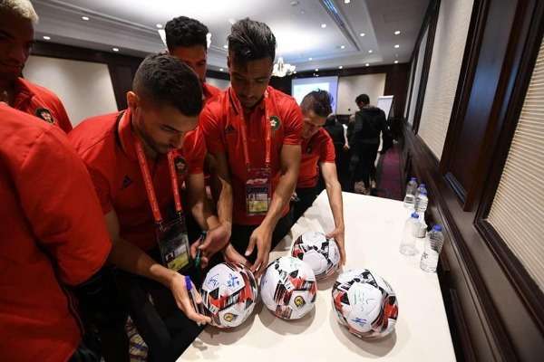 لاعبو المنتخب المغربي يوقعون الكرات