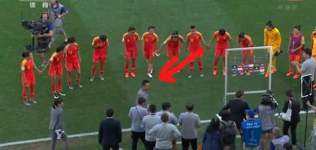 صورة تلفزيونية للمدرب شيوكوان وهو يدير ظهره على اللاعبات
