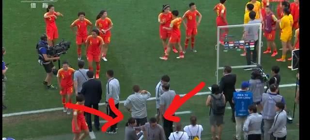 صورة تلفزيونية للمدرب شيوكوان وهو يدير ظهره على اللاعبات