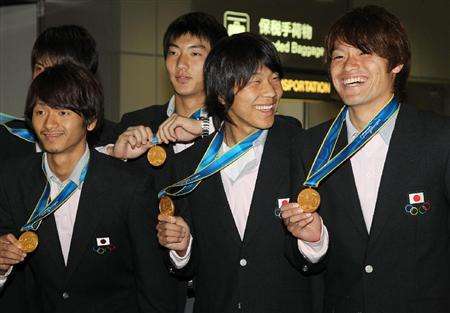 كينسوكي ناغاي ( وسط ) تلقى الإستقبال الحافل من الإتحاد الياباني في مطار ناريتا