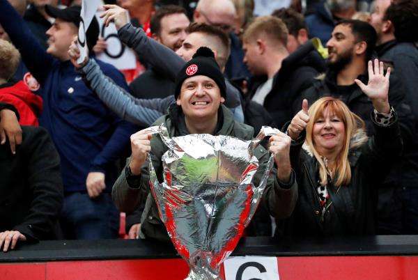 مشجع يحمل مجسمًا لكأس البريميرليج